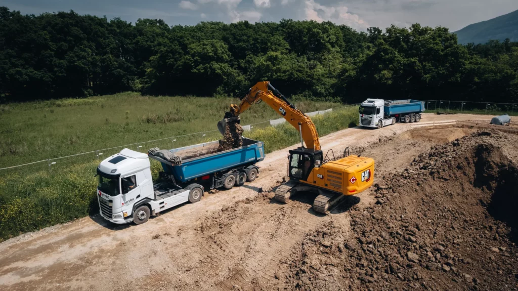 Pelle chargeant un camion sur le chantier du Quartier des Grands Esserts à Veyrier
