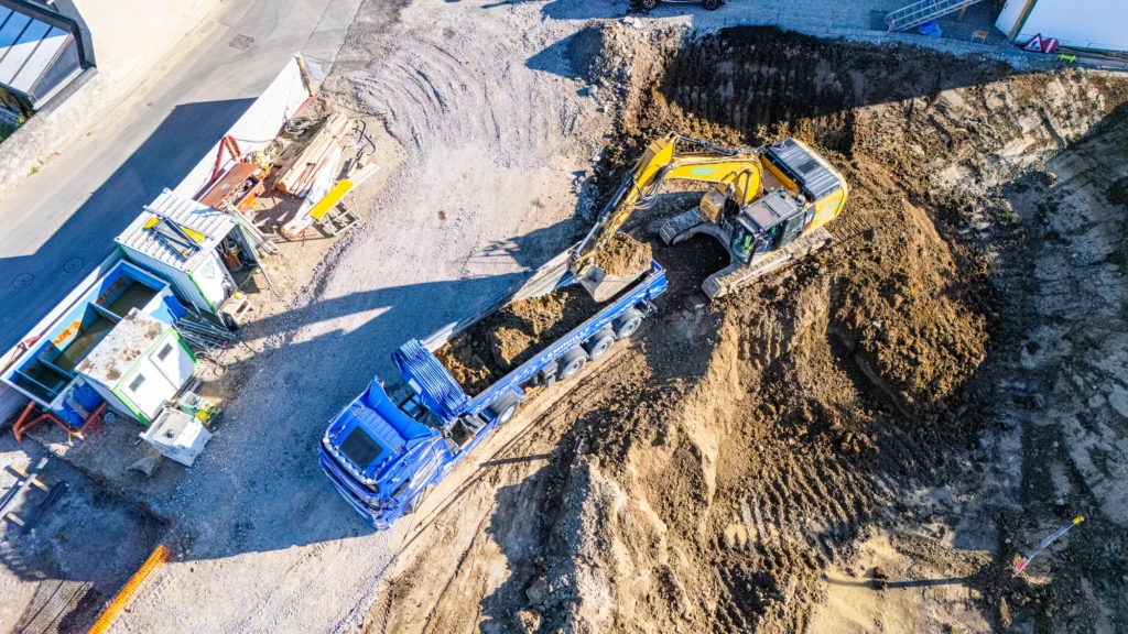 Pelle mécanique chargeant un camion benne ECOM3 sur le chantier de terrassement de Lullier à Jussy