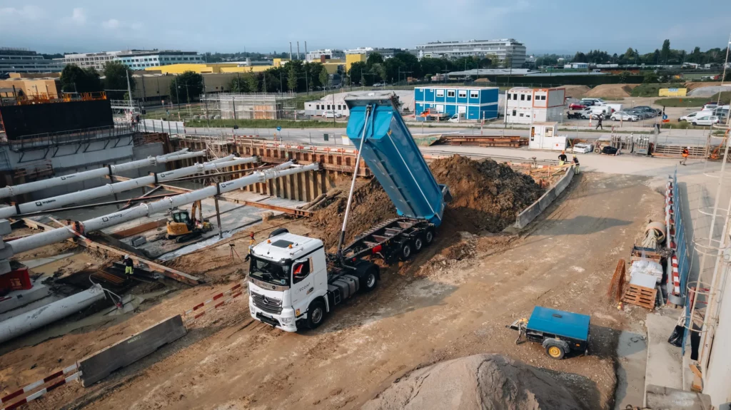 Camion benne ECOM3 déchargeant des déblais sur le chantier du Quartier des Cherpines